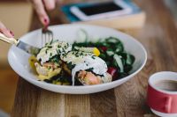 Kaboompics - Close up image of young woman eating classic breakfast at restaurant