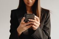 Kaboompics - Close-Up of Hands Holding a Smartphone in a Black Suit
