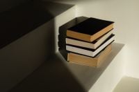 Kaboompics - Minimalist Interior with Stack of Books on Sunlit Shelf