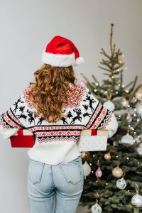 Kaboompics - Rear View of Woman Holding Christmas Gifts in a Santa Hat