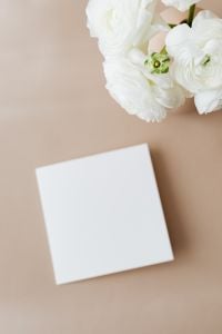 Kaboompics - White Flower and Blank Card Mockup on a Beige Background
