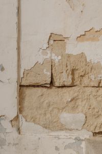 Kaboompics - Peeling White Plaster Revealing Rough Limestone Wall Texture
