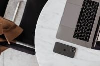 Kaboompics - Top View of MacBook Pro and iPhone 11 Pro on a Round Marble Table, Minimal Apple Workspace and Mobile Technology Flat Lay