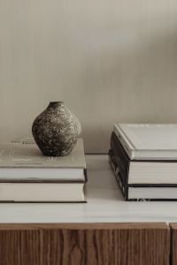 Kaboompics - Speckled Ceramic Vase Between Stacks of Interior Design Books