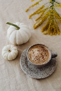 Kaboompics - Speckled Cappuccino with Two White Pumpkins and Goldenrod, Overhead Beige Linen Background