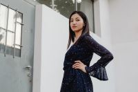 Kaboompics - Asian Fashion Model with Hand on Waist in Navy Polka Dot Dress and White Wall