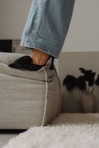 Kaboompics - Close-Up of a Black Stiletto Heel with Denim on an Upholstered Chair