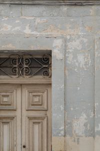 Kaboompics - Peeling Blue Gray Facade with Decorative Iron Door Grille