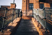 Kaboompics - Person Walking Up Brick Steps Between Metal Railings