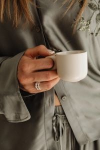 Kaboompics - Close-Up of a Woman Holding a White Coffee Cup in Satin Loungewear