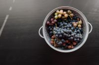 Kaboompics - Colander Filled With Mixed Grapes on a Black Table