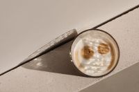 Kaboompics - Foamy Glass Coffee on an Angled Stone Ledge with Soft Shadow