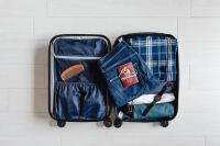 Kaboompics - Overhead Open Suitcase with Folded Clothes, Comb, Denim and a Wristwatch