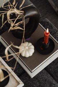 Kaboompics - White Pumpkin and Red Candle on Stacked Books