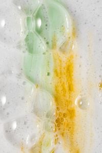 Kaboompics - Glossy Mint Gel and Amber Cream Swirls in White Foam, Skincare Product Macro
