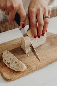 Kaboompics - Close-Up of Slicing Rustic Bread on a Wooden Board