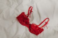 Kaboompics - Red Satin Bra Styled on White Sheets