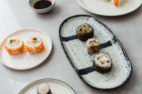 Kaboompics - Sushi Sampler with Nori Rolls and Tobiko Maki on Ceramic Plates