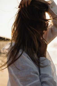Kaboompics - Faceless Woman with Windblown Hair in White Linen Shirt