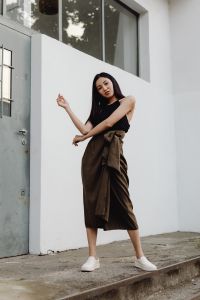 Kaboompics - Asian Woman Posing with Raised Arms in Black Top and Brown Wrap Skirt