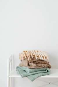 Kaboompics - Folded Pastel Sweaters on a White Shelf