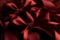Kaboompics - Wrapped Red Gift with Satin Bow on Textured Fabric