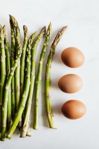Kaboompics - Vertical Asparagus and Brown Eggs on White with Clear Copy Space