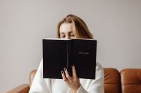 Kaboompics - Woman Holding a Holy Bible in Front of Her Face