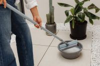 Kaboompics - Woman Cleaning a Mop Head in a Water Bowl
