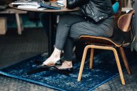 Kaboompics - Woman Sitting on Wooden Chair over Blue Living Room Rug
