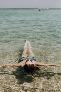 Kaboompics - Woman Floating on Her Back in Clear Shallow Sea with Arms Outstretched