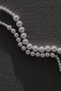 Kaboompics - Black and White Pearl Necklace on Dark Sand, Monochrome Fashion Detail
