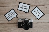 Kaboompics - Little cards with inspirational quotes and a black camera