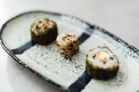Kaboompics - Nori and Sesame Sushi Rolls on a Rustic Blue Ceramic Platter