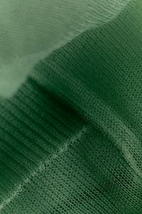 Kaboompics - Forest green sheer fabric with ribbed knit layer, draped close-up