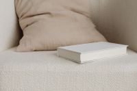 Kaboompics - Horizontal Blank Book Cover Mockup on Textured Cream Upholstery
