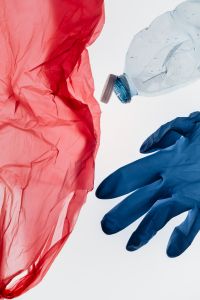 Kaboompics - Red Plastic Bag With Bottle And Glove Minimal Scene