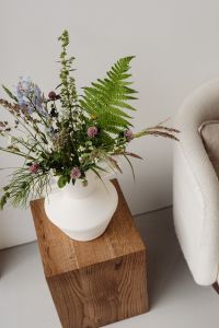 Kaboompics - Wildflower Bouquet in White Vase beside Textured Armchair