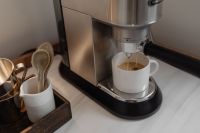 Kaboompics - Foamy Espresso Brewing into a White Mug