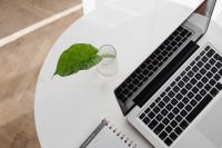 Kaboompics - Close-Up Laptop and Open Planner by a Leather Sofa, Neutral Work From Home Editorial
