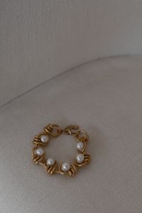 Kaboompics - Gold Link Bracelet with Pearl Beads on Neutral Fabric, Minimal Jewelry Still Life