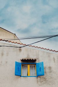 Kaboompics - Yellow Window with Open Blue Shutters under a Mediterranean Sky in Rovinj