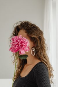 Kaboompics - Woman Holding a Pink Peony against a Black Top