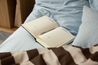 Kaboompics - Open Book on Blue Bedding in Cozy Bedroom