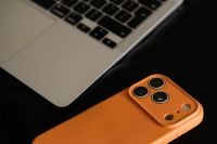 Kaboompics - Close Up of Orange Smartphone Beside Laptop Keyboard