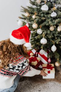 Kaboompics - Woman in Santa Hat Stacking Presents by a Christmas Tree