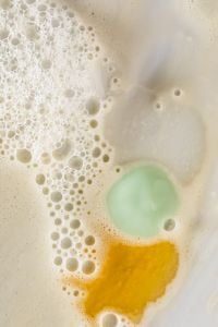Kaboompics - Golden and Sage Skincare Cream Drops in Foamy White Texture
