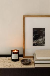 Kaboompics - Travertine Console Styling with Lit Candle, Stone Bowl, Books and Framed Art