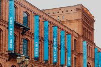 Kaboompics - Historic Red-Brick Manufaktura Facade Lined with Blue Event Banners in Łódź, Poland