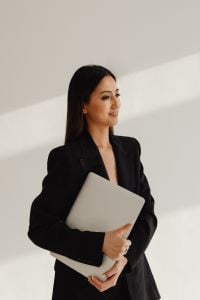 Kaboompics - Asian Businesswoman Holding a Laptop in a Bright Office
